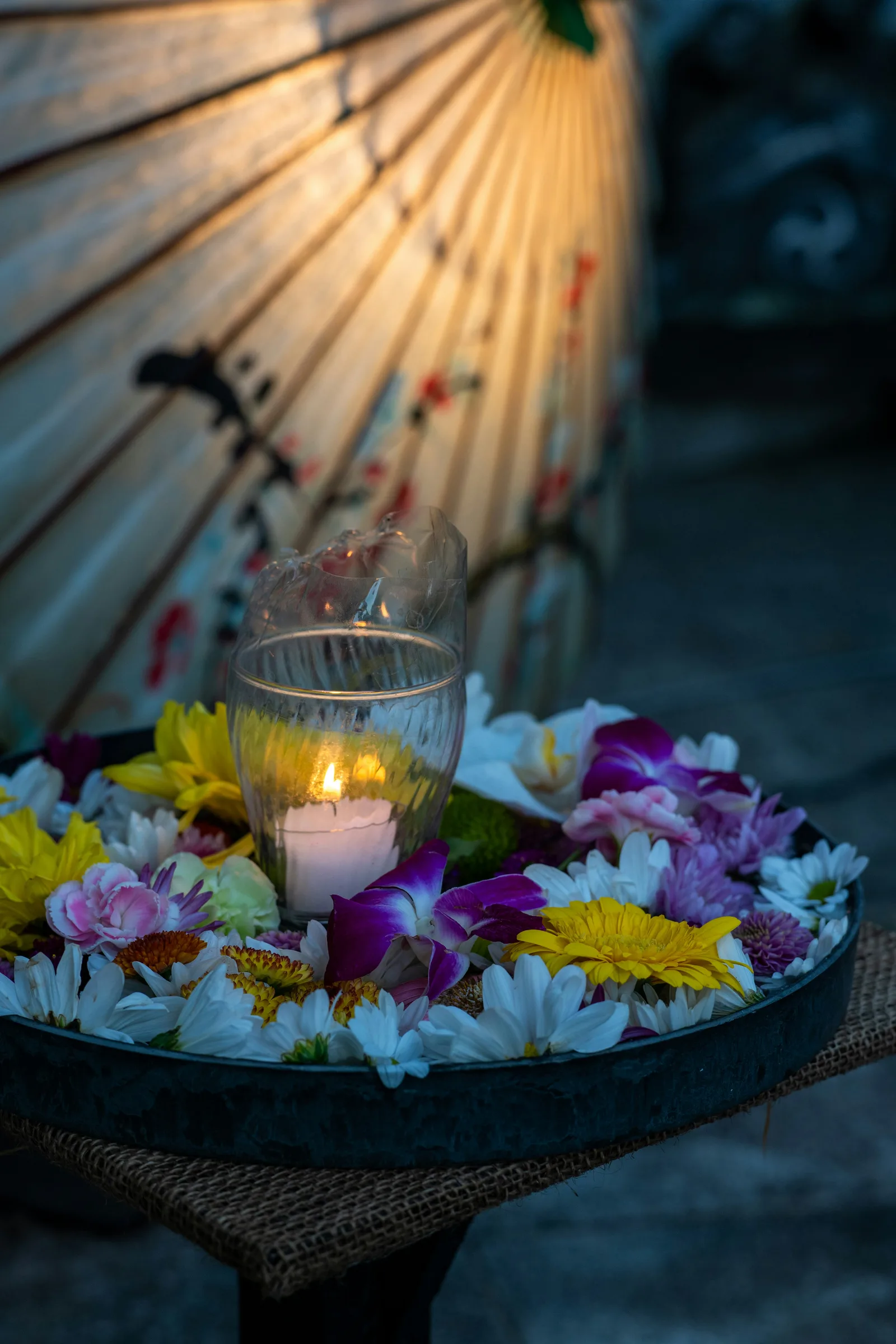 Candle surrounded by colorful spa flowers